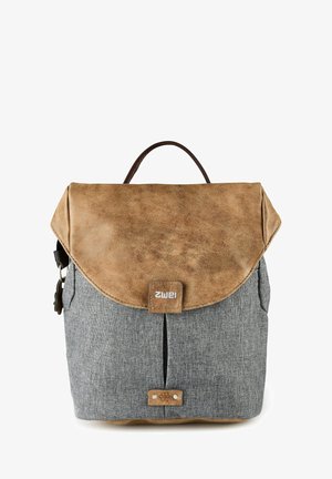 Zaino con corpo in tessuto grigio e patta, manico e base in pelle marrone, con linguetta frontale decorata da un piccolo emblema floreale.