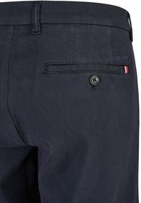 Navyblauwe textuurbroek met een achterzak met een ronde zwarte knoop en een kleine rood, wit en blauw accentstreep.