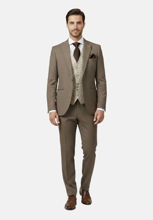 Hombre caminando hacia adelante con un traje marrón, chaleco beige con patrón, camisa blanca, corbata oscura con diseño y zapatos de vestir marrones.