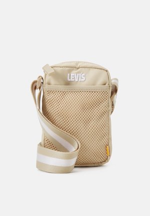 Beige Levi's crossbody bag with front mesh pocket, white embroidered logo, and adjustable beige and white striped shoulder strap.