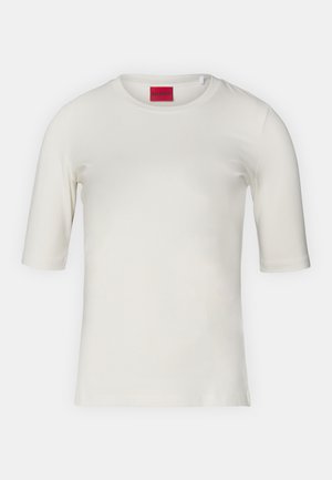 T-shirt branca de mangas curtas feita de algodão suave, com decote redondo e uma etiqueta de logotipo discreta em vermelho na parte interna do colarinho.
