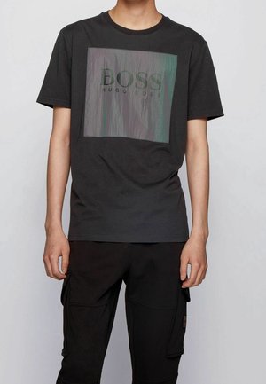 Czarny bawełniany t-shirt z prostokątną, iryzującą grafiką z napisem "BOSS HUGO BOSS" na środku, z okrągłym dekoltem.