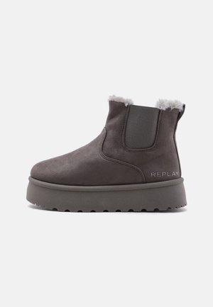 Bottine en daim gris foncé avec semelle épaisse, panneau latéral élastique, doublure en fourrure blanche et logo "REPLAY" côté talon.