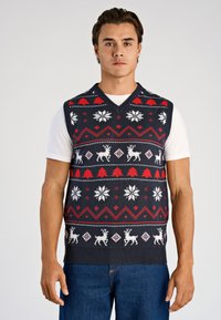 Chaleco sin mangas azul marino con copos de nieve blancos, renos y acentos rojos en un patrón geométrico. Hecho de material de punto con diseño de cuello en V.