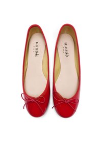 Ballerines en cuir verni rouge avec un bout rond, un élastique sur le pourtour et un nœud en ruban à l'avant. Doublure intérieure beige douce.