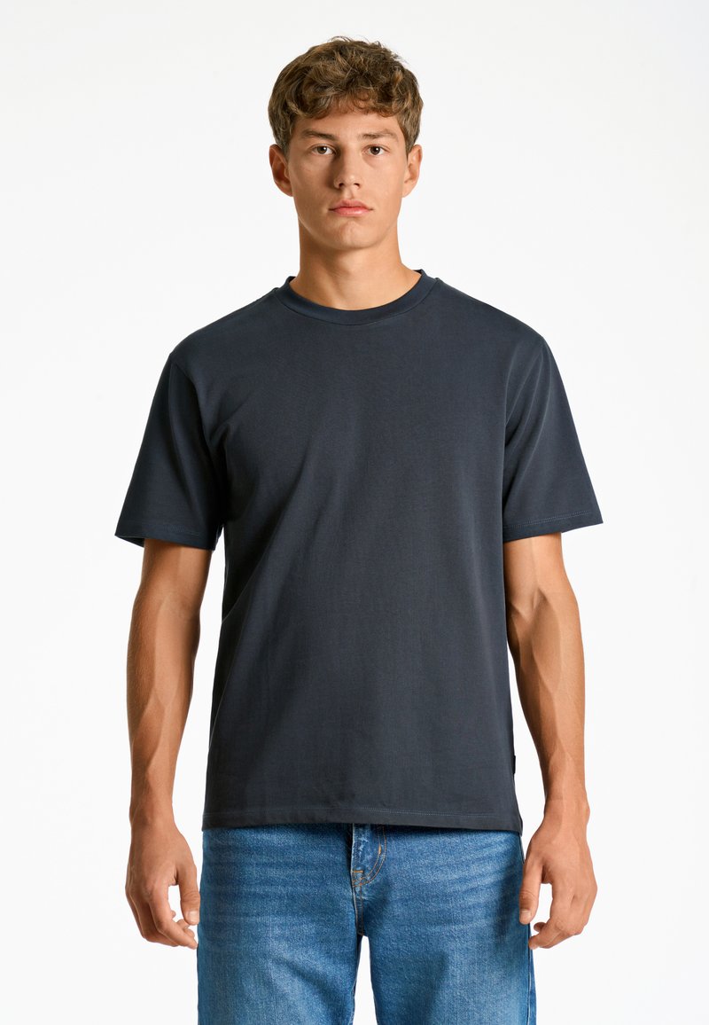 Tumma harmaa puuvillapaita lyhyillä hihoilla ja pyöreällä kaula-aukolla, joka omaa sileän pinnan ja rennon, suorakulmaisen leikkauksen.