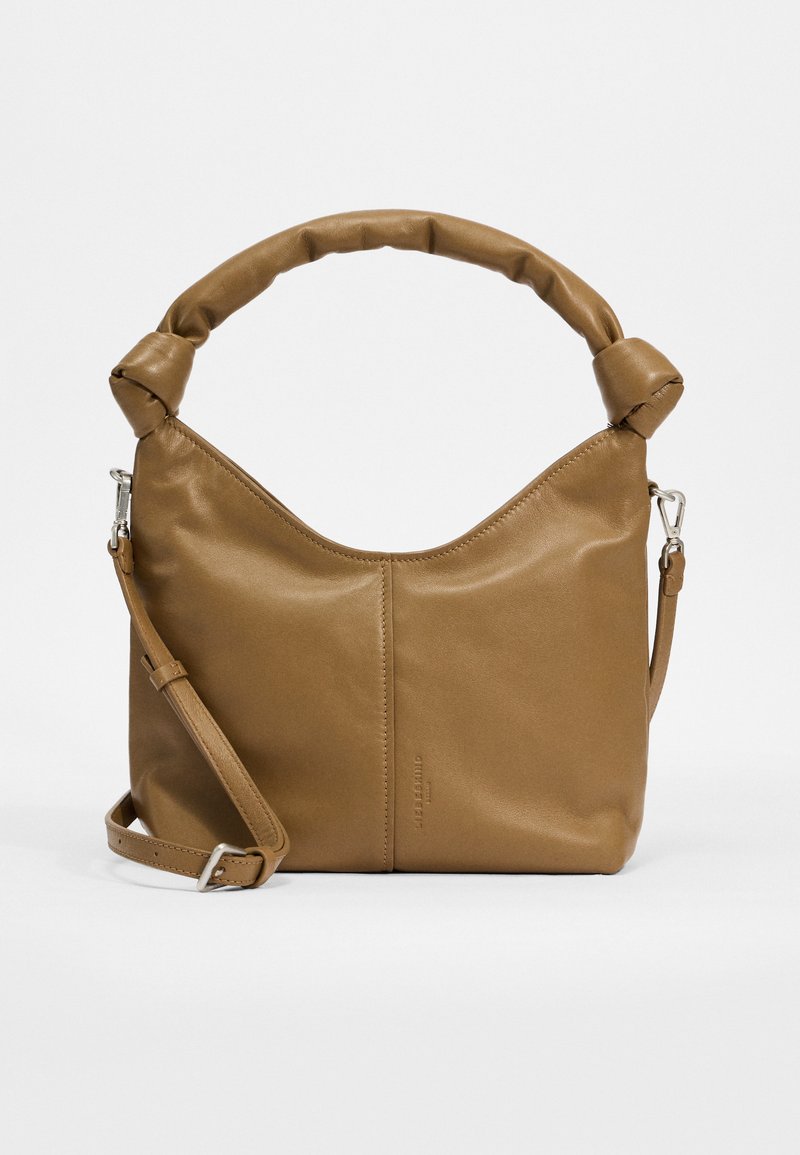 Braune Lederhandtasche mit einem runden, gepolsterten Griff, verstellbarem Schultergurt und schlankem, minimalistischen Design. Besitzt eine glatte Textur.