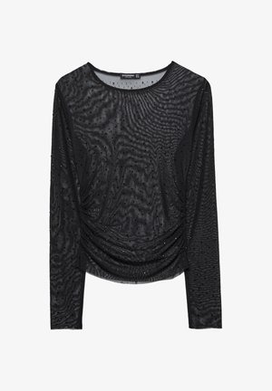 Haut noir à manches longues en tissu transparent, avec un motif texturé et des accents de perles éparpillées, présentant des détails froncés à la taille.