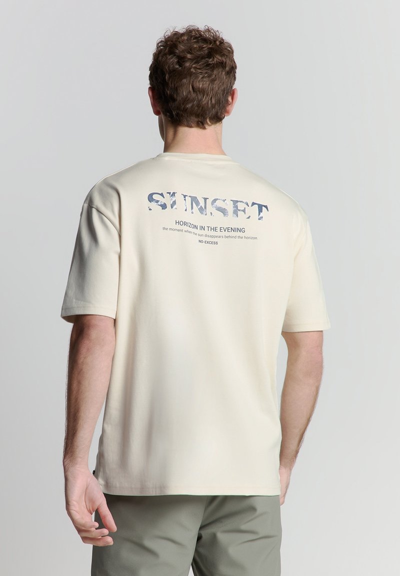 Beige katoenen T-shirt met ronde hals, korte mouwen en een grafische print op de achterkant met tekst in blauw en grijs.