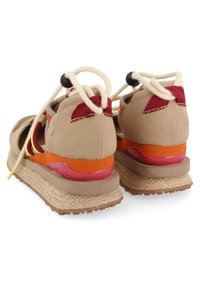 Sandales beiges avec un dessus texturé, des accents orange et rouge, des lacets élastiques et une semelle d'espadrille à plusieurs couches avec une section rose.