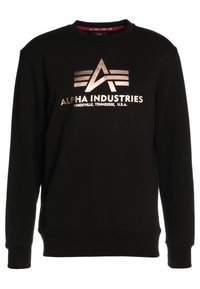 Musta crewneck-sweatshirt, jossa on metallinen Alpha Industries -logo ja teksti "Knoxville, Tennessee, Yhdysvallat" edessä.