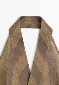 Brunt linnedstof med diagonale grå striber foldet til en V-formet krave eller tørklæde på en hvid baggrund.