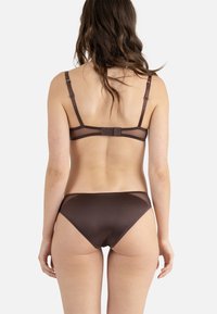 Ensemble bralette et bikini en tissu marron mat avec des panneaux en mesh transparent, des bretelles ajustables et une fermeture à crochet au dos.