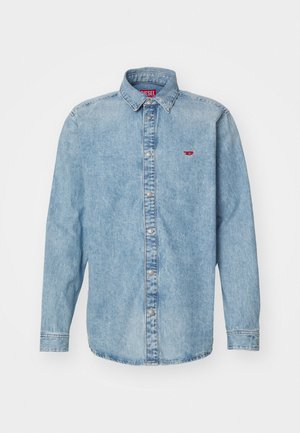 Camisa de ganga azul clara com mangas longas, colarinho pontiagudo e fecho com botões. Apresenta um pequeno logo vermelho na área do peito esquerdo.