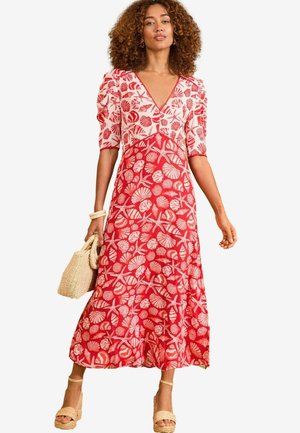 Red dress with white shell and starfish patterns, short puff sleeves, V-neckline, and a flowing skirt that reaches mid-calf. Woven bag included.