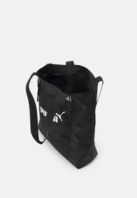 Sac fourre-tout en tissu noir avec un logo, deux bretelles, une fermeture éclair et un motif géométrique simple sur la surface.