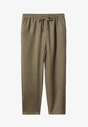 Jersey de cuello cisne sin mangas en color crema, pantalones anchos de talle alto en tono oliva con cordón, y botines de ante marrón con tacón, en persona de pie.