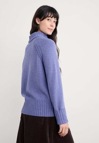 Paarse coltrui gemaakt van zachte stof, met ribbels aan de mouwen en onderkant, met een relaxte pasvorm en een gladde textuur.