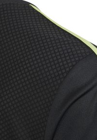 Camiseta deportiva negra con un patrón texturizado y acentos en verde lima a lo largo de la costura del hombro. Cuenta con tela transpirable y un diseño ajustado.