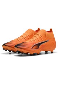 Scarpe da calcio arancioni con una superficie testurizzata e decorata e un accento nero. Presentano un collo alto e numerosi tacchetti neri sulla suola.