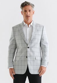 Jasnoszary marynarka w kratę z niebieskimi akcentami, z jednopunktowym zapięciem, klapami w kształcie notcha i dwoma przednimi kieszeniami, noszona na białej koszuli.