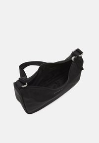 Musta vetoketjullinen kangaspussukka, suorakulmainen muoto ja olkahihna. Sisäosassa on yksi osasto, jossa sileä pinta.