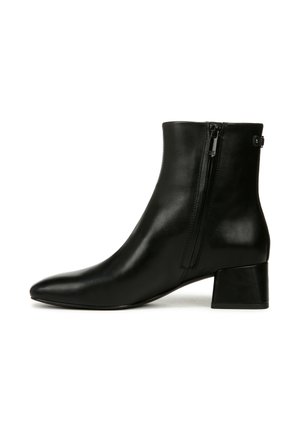 Botte de cheville en cuir noir avec un bout pointu et un petit talon épais. Dotée d'une fermeture éclair à l'arrière pour un enfilage facile.