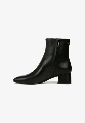 Botte de cheville en cuir noir avec un bout pointu et un petit talon épais. Dotée d'une fermeture éclair à l'arrière pour un enfilage facile.