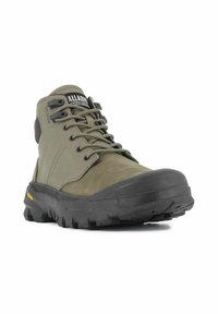Bota de senderismo verde de media altura con upper de ante texturizado, puntera de goma y suela con patrón, que presenta cordones negros y una etiqueta con logo.