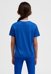 Blå kortärmad skjorta med vertikala ränder och rundad vit krage, i kombination med matchande blå leggings. Slät textur.