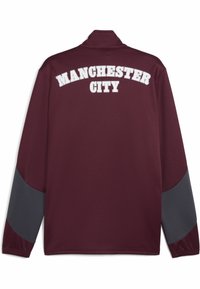 Bordeaux træningsjakke med grå ærmeakcenter og "MANCHESTER CITY" trykt i hvidt på ryggen. Blødt materiale, design med lynlås i kraven.