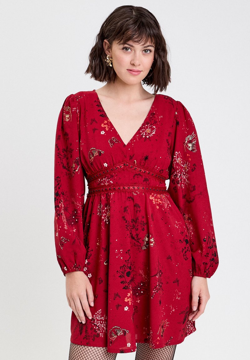 Red floral dress with a V-neck, long puff sleeves, and an elastic waist. Features intricate patterns and a gathered skirt.