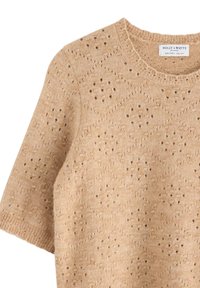 Maglione beige lavorato a maglia con collo rotondo e maniche corte, caratterizzato da una texture a motivi con piccoli fori e orlo a coste.