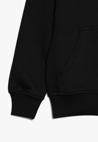 Felpa nera in tessuto con tasca a marsupio e polsini a coste. Il design presenta dettagli di cucitura e una texture morbida.