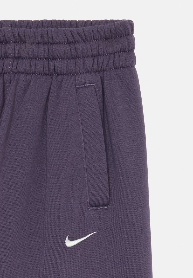 Lila Sweatpants mit elastischem Bund, Seitentaschen und einem weißen Nike-Logo. Hergestellt aus weichem, strukturiertem Stoff.