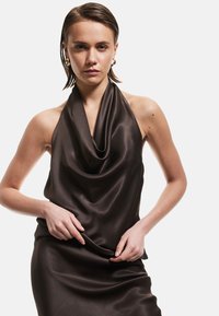 Bruine satijnen haltertop met gedrapeerde halslijn. Gladde textuur, aansluitend ontwerp, geaccentueerd door minimalistische styling en elegante draping.