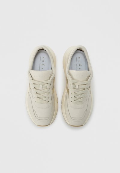 Μπεζ αθλητικά παπούτσια με λείο δερμάτινο επάνω μέρος, μαλακό ενδιάμεσο πέλμα, λεπτά κορδόνια και στρογγυλεμένο σχέδιο μύτης. Διαθέτουν διακριτικό λογότυπο στη γλώσσα.