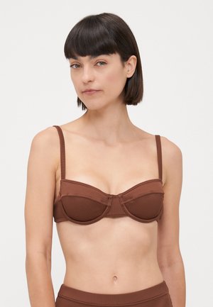 Brown ribbed bikini top with a structured, underwired design. Features thin adjustable straps and a horizontal seam across the cups.