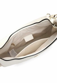 Hvid læderne tote taske med en sort lynlås. Indersiden er i beige stof med to lommer til organisering og en mærkattag.