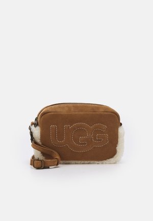 Brązowa zamszowa prostokątna torba na ramię z białymi krawędziami z shearling oraz wyhaftowanym napisem „UGG” z przodu, regulowany pasek i zapięcie na suwak.