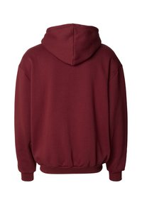 Bordo vilnas kapuce ar mīkstu tekstūru, lielu kapuci un ribotiem aprocēm. Piedāvā brīvu piegriezumu un elastīgu apakšdaļu komfortam.