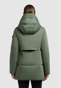 Cappotto imbottito verde con colletto alto e cappuccio oversize. Presenta un logo sul retro, una vestibilità rilassata e dettagli di cucitura sottili.
