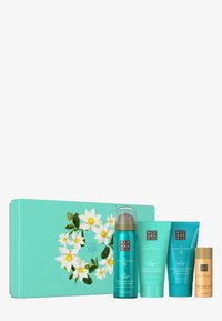 Set di quattro prodotti per la cura del corpo in contenitori turchesi, con un motivo floreale su una confezione coordinata turchese. Include un gel schiumogeno, una pasta scrub, una lozione per il corpo e un olio.