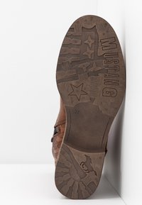 Brown shoe sole with embossed patterns including stars, arrows, and a galloping horse. Material appears textured and durable. Size "37" marked on sole.