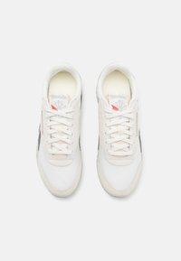 Baskets Reebok avec une tige en cuir blanc, des accents gris et une semelle en caoutchouc texturé. Dotées de lacets plats et d'un intérieur rembourré.