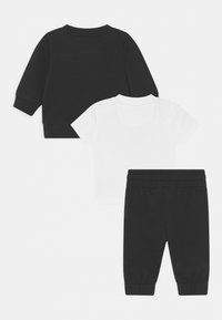 Haut noir à manches longues, haut blanc à manches courtes et pantalon noir. Tissu en coton, coupe décontractée, taille élastique et chevilles resserrées pour le pantalon.