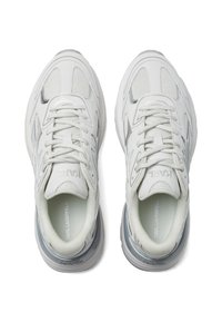 Zapatillas deportivas blancas con material de malla y cuero, diseño de cordones, cuello acolchado y sutiles acentos grises en las suelas y detalles de marca.