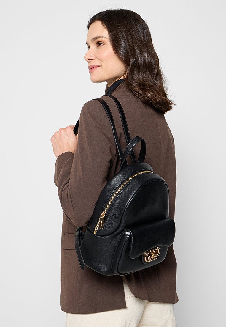 Zaino in pelle nera con forma arrotondata, cerniera dorata e patta frontale con dettaglio logo. Dotato di due spallacci regolabili.
