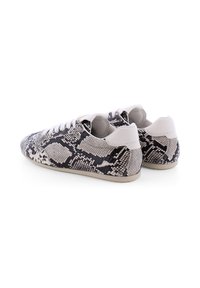 Schwarz-weiße Sneaker mit Schlangenhaut-Muster, ausgestattet mit einem Low-Top-Design und weißen Schnürsenkeln. Glatte Gummisohle und strukturierte Oberseite.