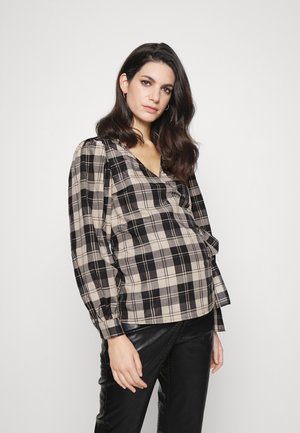 Blusa xadrez em bege e preto, com decote em V, mangas longas bufantes e um corte descontraído. Tecido texturizado com padrão de xadrez visível.